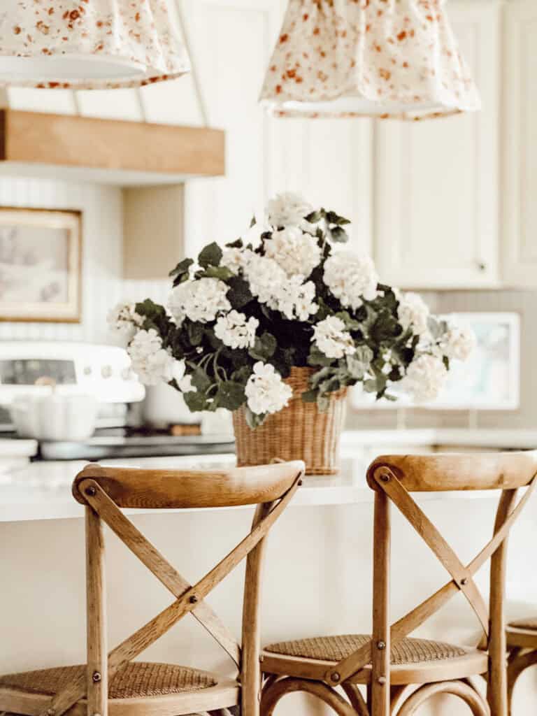 kitchen island with a basket of white hydrangeas in it.