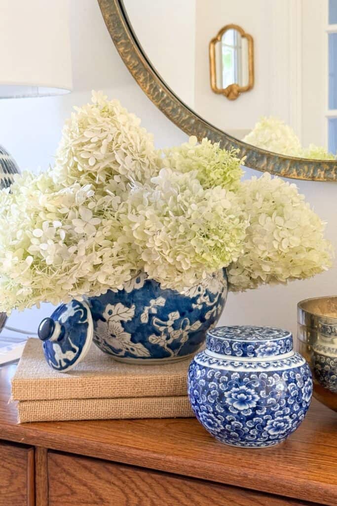 chinoiserie bowl with fresh cut hydrangeas on a table with other chinoiserie