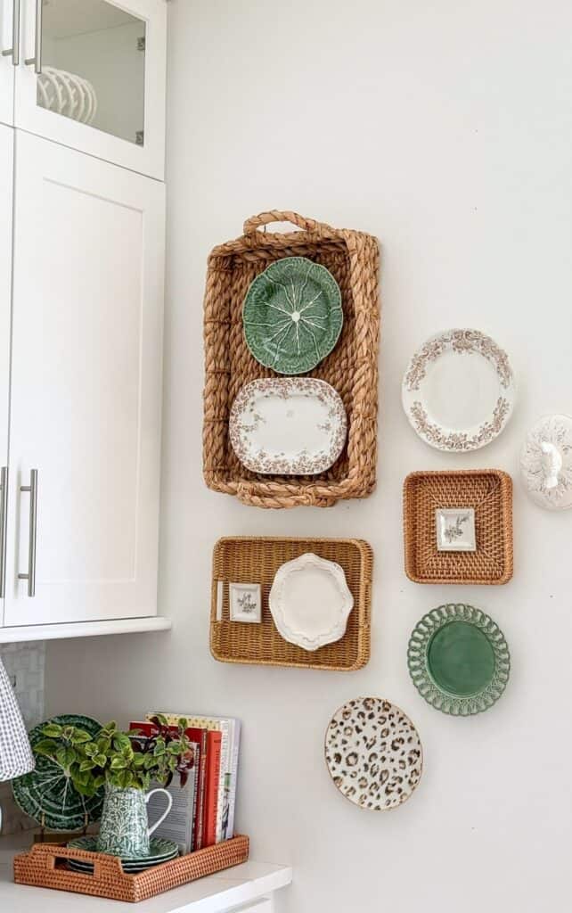 Basket and plate wall decor in a white kitchen with woven trays and vintage plates