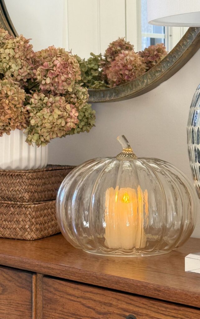 a glass pumpkin with a candle in it