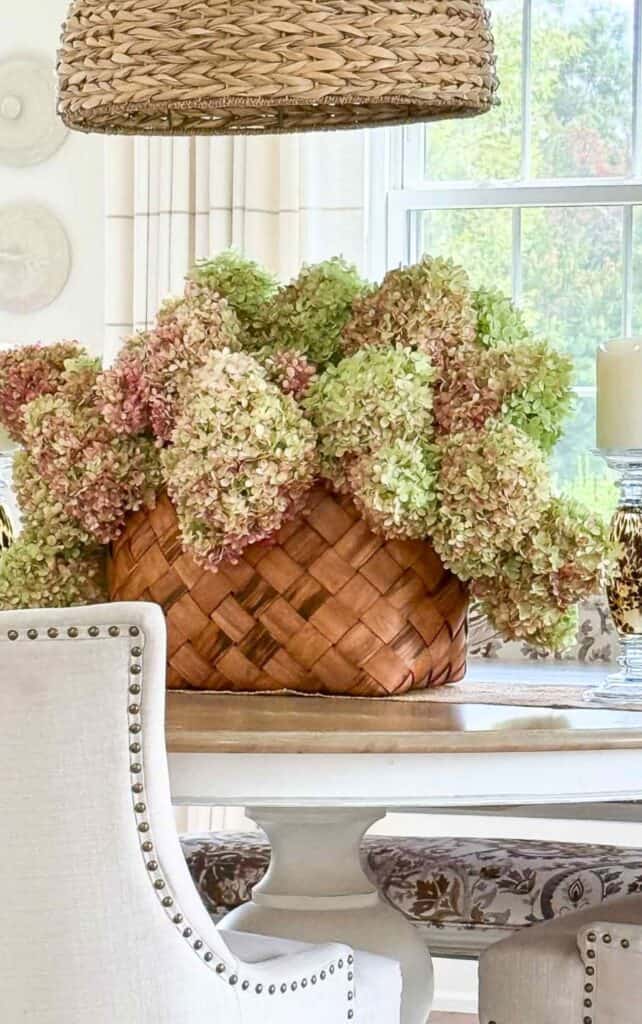 dried hydrangeas in a woven basket on a dining room table